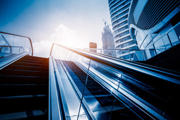 the escalator with modern buildings in the cityscape.