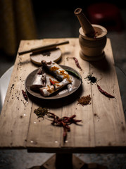 Indian fishes decorated with whole spices kept on a wooden dish on a wooden tray. Food photography.