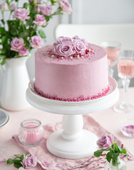 Obraz na płótnie Canvas festive pink cake on white cake stand decorated with fresh roses for Valentines Day