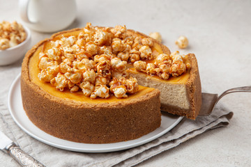 delicious caramel cheesecake with popcorn and salted caramel sauce on white background