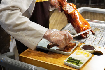 Peking duck being sliced and served. It is a dish from Beijing that has been prepared since the...