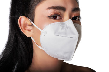 Close up of a young Asia woman putting on a respirator N95 mask to protect from airborne...