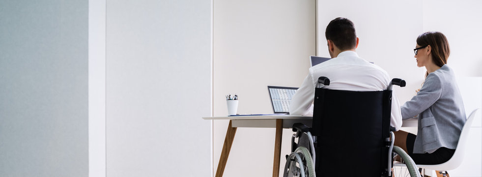 Disabled Businesswoman Sitting With Her Partner In Office