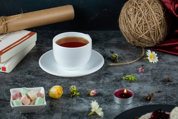A cup of tea with sweets and snacks