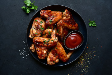 Grilled spicy chicken wings with ketchup. Top view with copy space.
