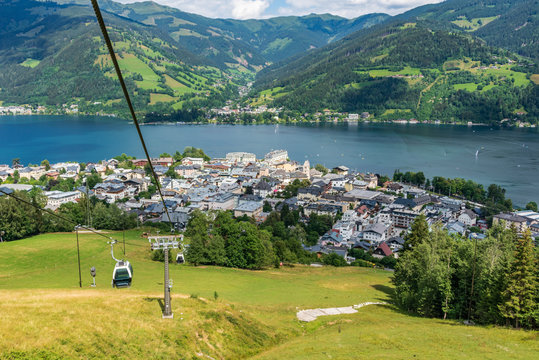 Cityscape of apine city Zell am See and  Zeller Lake in Austria. Summer meadows, ski gondolas and view of Tirol mountains Alps.