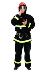 Portrait of a fireman with a phone in his hands in a black uniform in a red helmet on a white isolated background