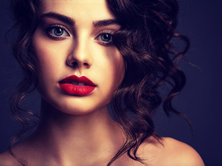Fototapeta premium Face of a beautiful woman with a smoky eye makeup and red lipstick