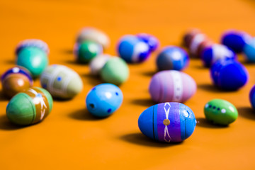 multicolored wooden eggs on orange background