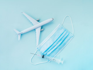 Airplane model, respiratory protection medical masks and disposable syringe.Concept of coronavirus, COVID-19 pandemic, global quarantin