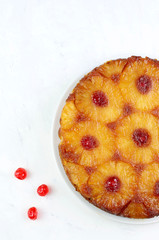 Cottura fatta in casa. Torta sottosopra dell'ananas con la ciliegia glacé isolata su fondo bianco Vista superiore.