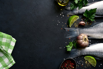 Raw fresh organic sea bass fish with spices and ingredients for making. Top view with copy space.