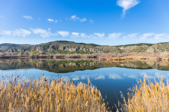 Laguna Picon de Los Conejos con reflejo de las monta&ntilde;as en Velilla de San Antonio