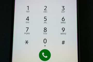 Smartphone keypad with black numbers on white background, close up