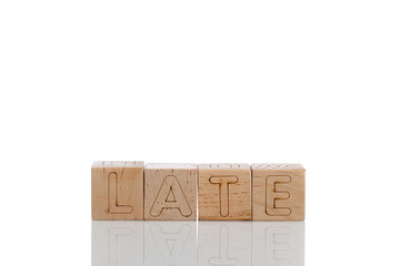 Wooden cubes with letters late on a white background