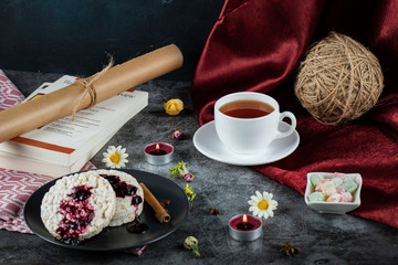 Dietary crackers with red jam and cinnamon and a cup of tea