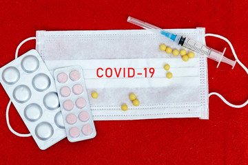 Abstract virus strain model of MERS-Cov or middle East respiratory syndrome coronavirus and Novel coronavirus 2019-nCoV with text on a red felt background.