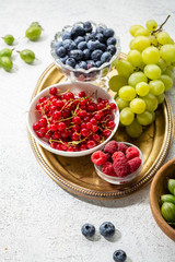 Various fruits and berries on platter, healthy leaving