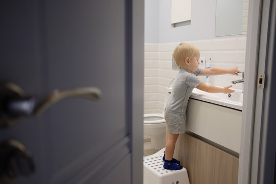 Little Blond Boy Learning Brushing His Teeth In Bath. Kid Learning How To Stay Healthy. Health Care Concept.