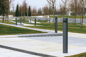 many low lighting fixtures are installed around the neat new tiled paths and green lawns in the modern Park
