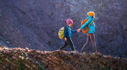 A boy with a backpack travels with his mother.
