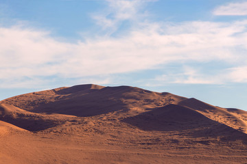 Red sand dune against a bright sky in the Namib desert