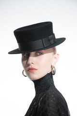 a woman on a white background with a black hat