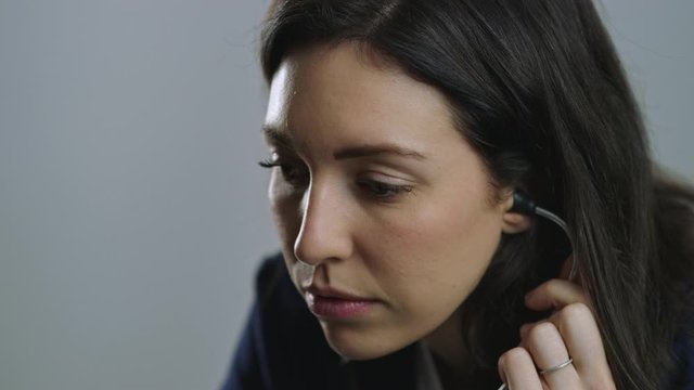Concerned female nurse puts on stethoscope and leans in to examine a patient