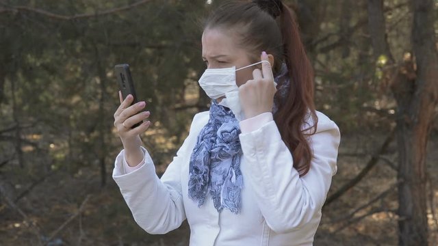 a woman in a mask wipes her smartphone with a disinfecting cloth, hygiene in diseases and epidemics