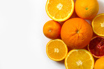 Close up image of juicy organic whole and halved assorted citrus fruits with visible core texture, isolated white background, copy space. Vitamin C loaded food concept. Top view, flat lay.