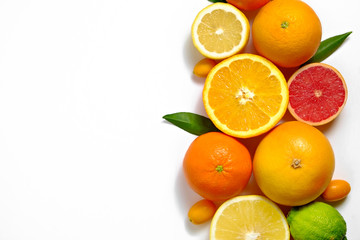 Close up image of juicy organic whole and halved assorted citrus fruits, green leaves & visible core texture, isolated white background, copy space. Vitamin C loaded food concept. Top view, flat lay.