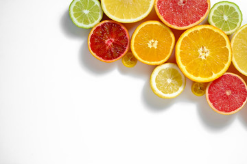 Close up image of juicy organic whole and halved assorted citrus fruits with visible core texture, isolated white background, copy space. Vitamin C loaded food concept. Top view, flat lay.