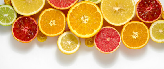 Close up image of juicy organic whole and halved assorted citrus fruits with visible core texture,...