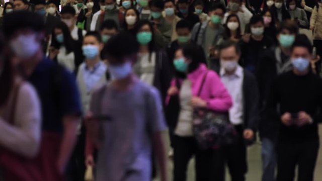 Slow motion of blurred unrecognized people wearing medical face masks at metro in Hong Kong.