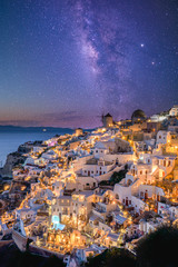 Oia village in sunset, night light stars and milky way, Santorini, Greece. Amazing summer vacation...