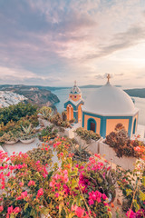 Obraz premium Beautiful sunset on Santorini island, Greece. Amazing flowers and church with sea view