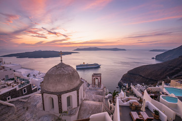 Beautiful summer landscape, luxury travel background. Amazing evening view of Fira, caldera, volcano of Santorini, Greece with cruise ships at sunset. Cloudy dramatic sky. - obrazy, fototapety, plakaty