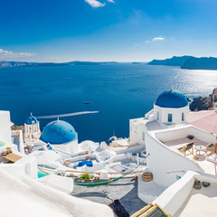 Fototapeta na wymiar Amazing summer landscape, luxury vacation. Oia town on Santorini island, Greece. Traditional and famous houses and churches with blue domes over the Caldera, Aegean sea