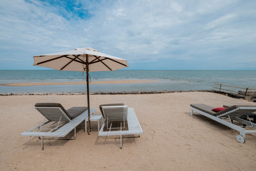 chairs and umbrella on tropical beach, vacation time after hard work