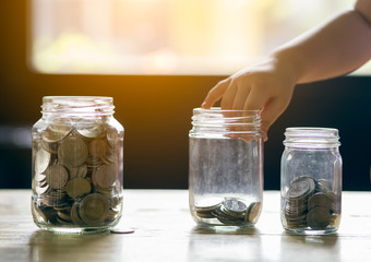 Fototapeta na wymiar saving money hand putting stack on table jug glass concept financial