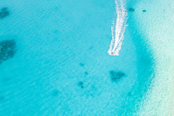 People are playing a jet ski in the sea.Aerial view. Top view.amazing nature background. The color of the water and beautifully bright. Fresh freedom. Adventure day clear turquoise at tropical beach