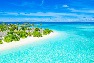 The drone photo with a wooden water villas seen from above and an amazing blue lagoon crystal clear water close to tropical lagoon. Amazing summer travel and vacation background. Dreamy beach scenery © icemanphotos
