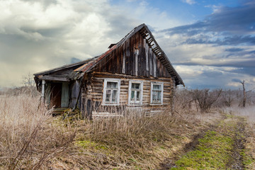 Fototapeta na wymiar Abandoned wooden house in a deserted village. Rural areas in Russia. Early spring.