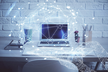 Computer on desktop with social network hologram. Multi exposure. Concept of international people connections.