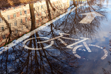 Bike path sign, puddles on the asphalt