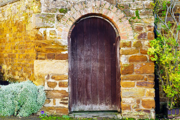 Fototapeta na wymiar old door stone wall building texture in england uk
