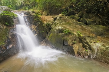 Fototapeta na wymiar view nature of silky stream water flowing around with many arch rocks and green forest background, Phong Phra Bat Waterfall, Chiang Rai, northern of Thailand.