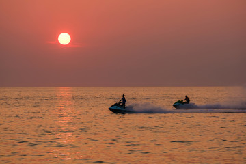 Young people ride a scooter on the sea