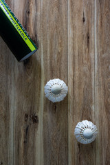 Old used shuttlecock on wooden background.