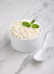 cottage cheese in a white ceramic form on a marble background